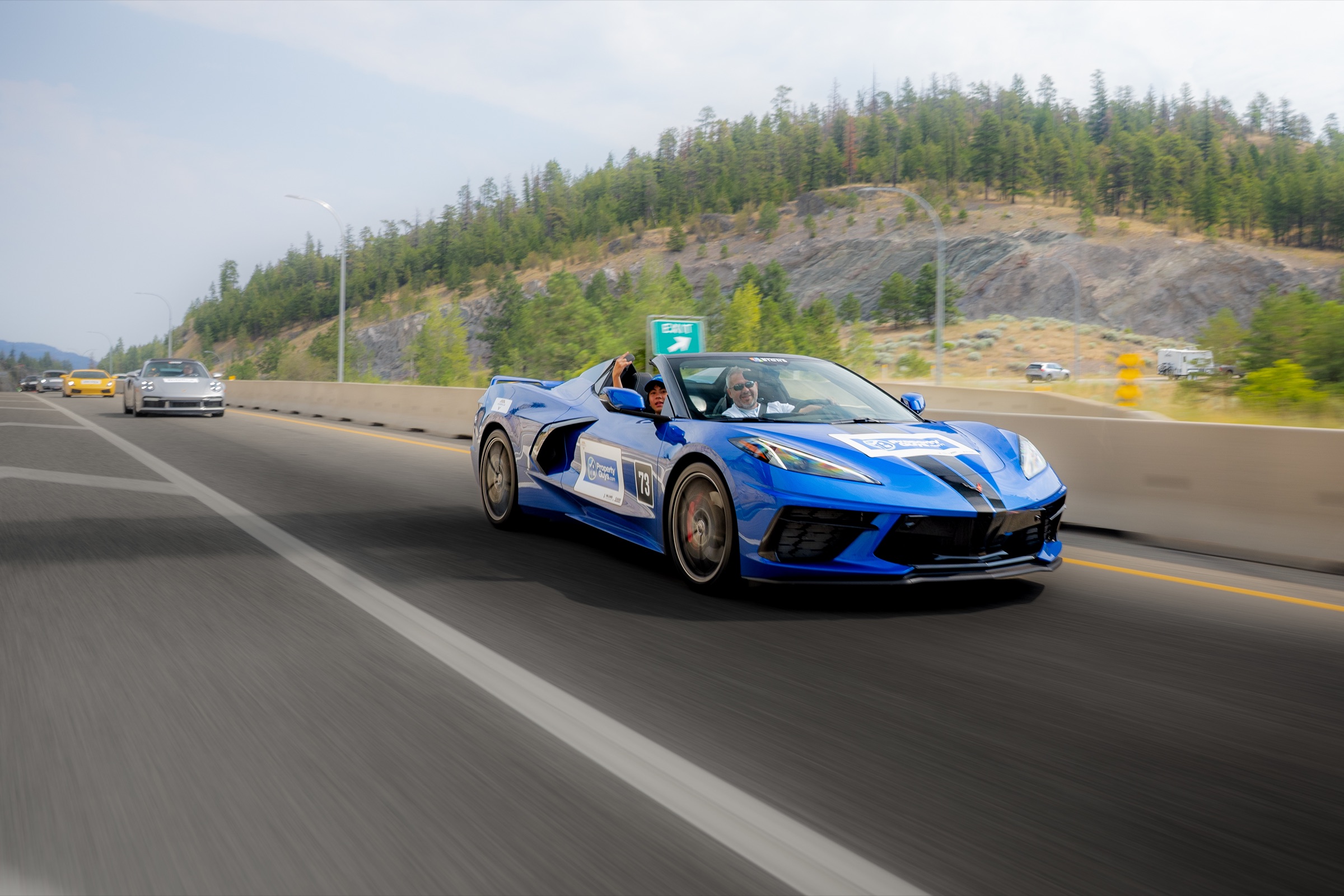 Blue Chevrolet Corvette convertible at speed through the Okanagan