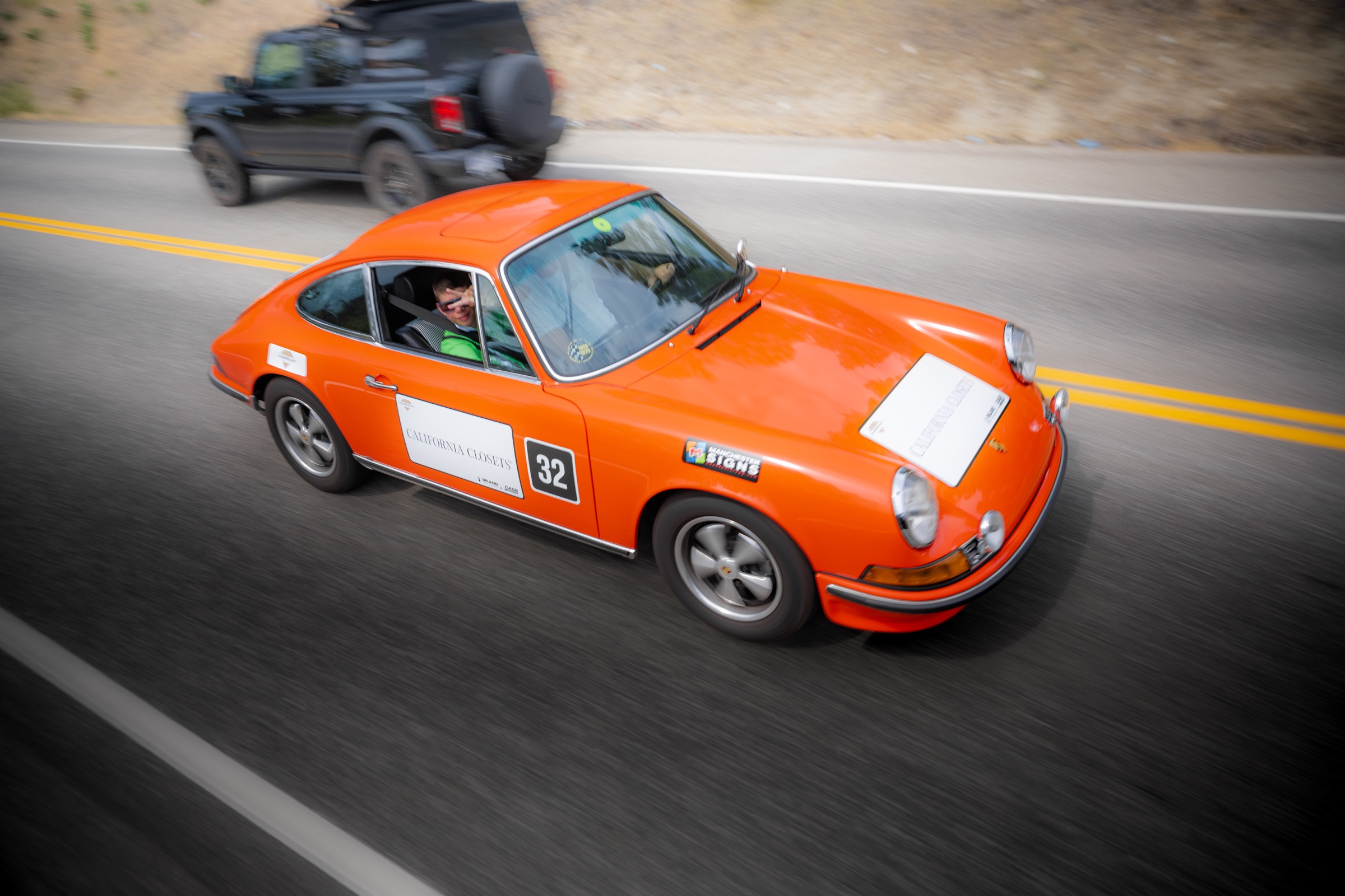 Orange classic Porsche 911 photographed in motion during the rally
