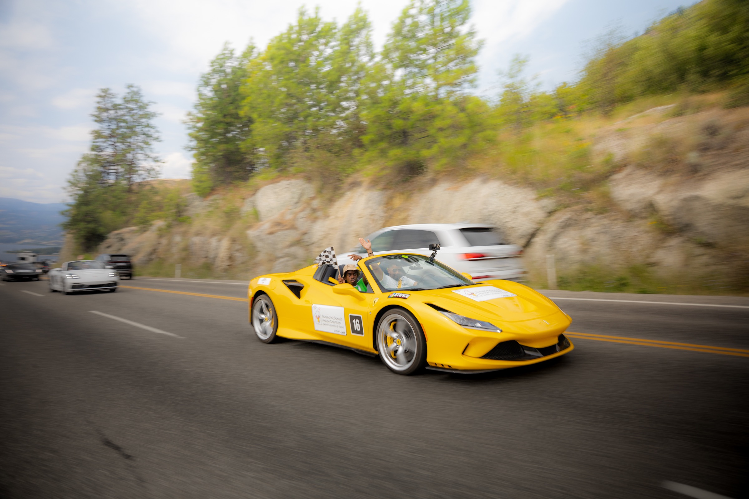 Yellow Ferrari carrying a smiling Dream Rally co-pilot