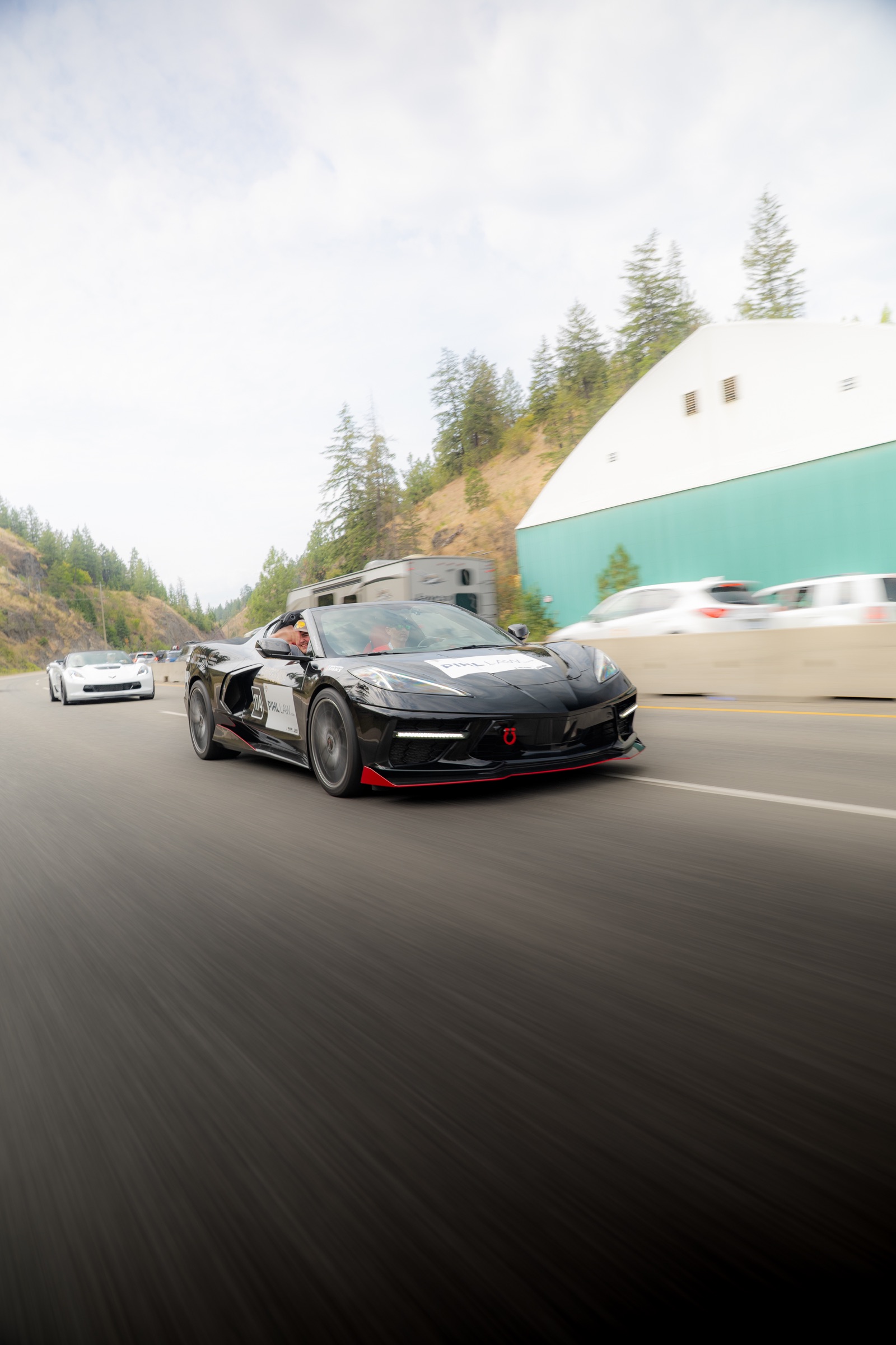 Black Chevrolet Corvette photographed in motion during the rally