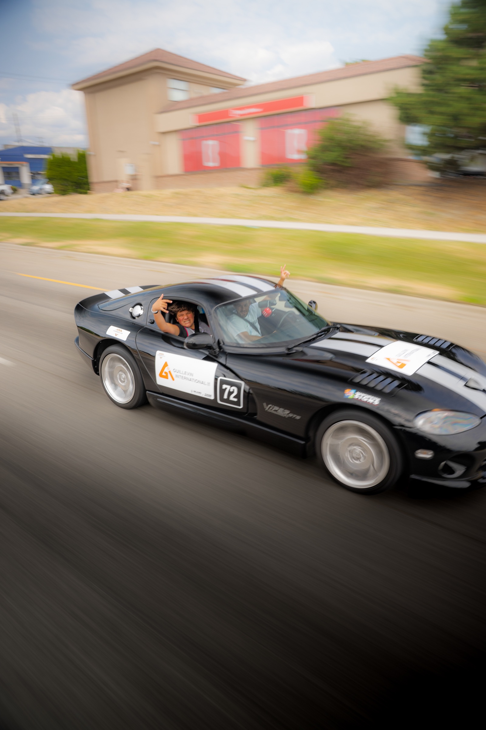 Dream Rally co-pilot waving from a black Dodge Viper