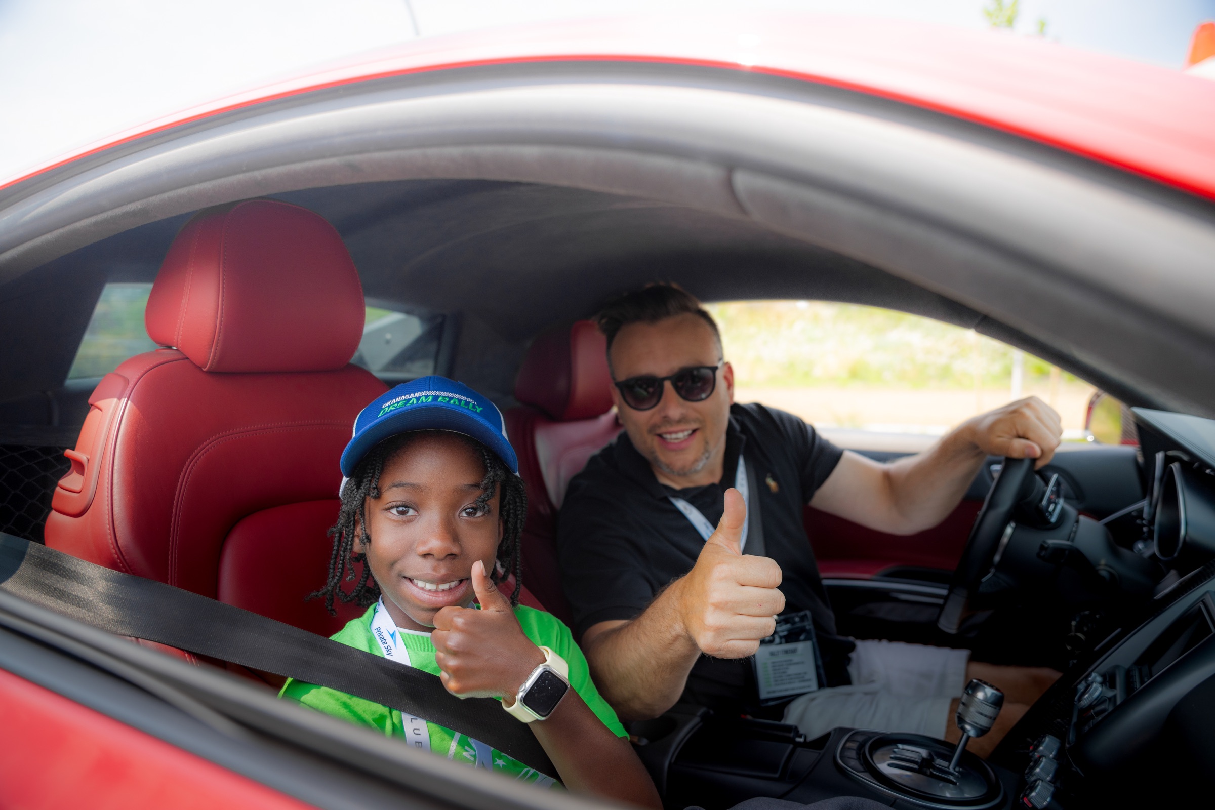Dream Rally co-pilot and driver giving thumbs up from a red Audi R8