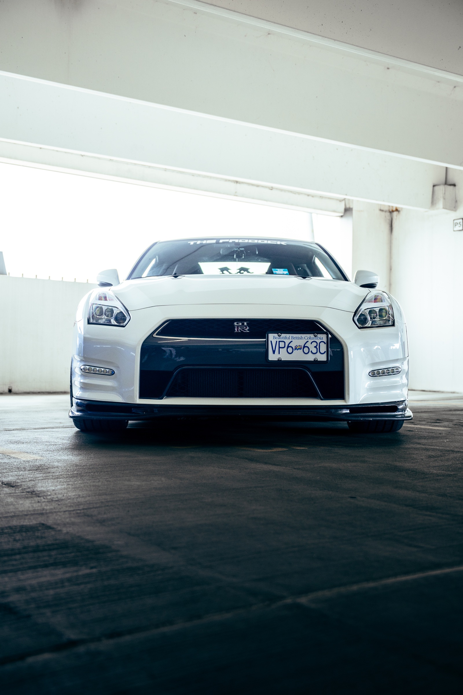 White Nissan GT-R photographed head-on inside the parkade