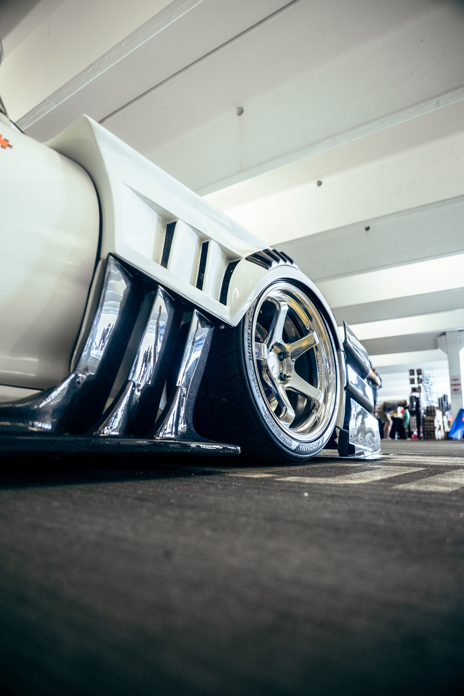 Polished wheel and aero detail on a white Mazda RX-7