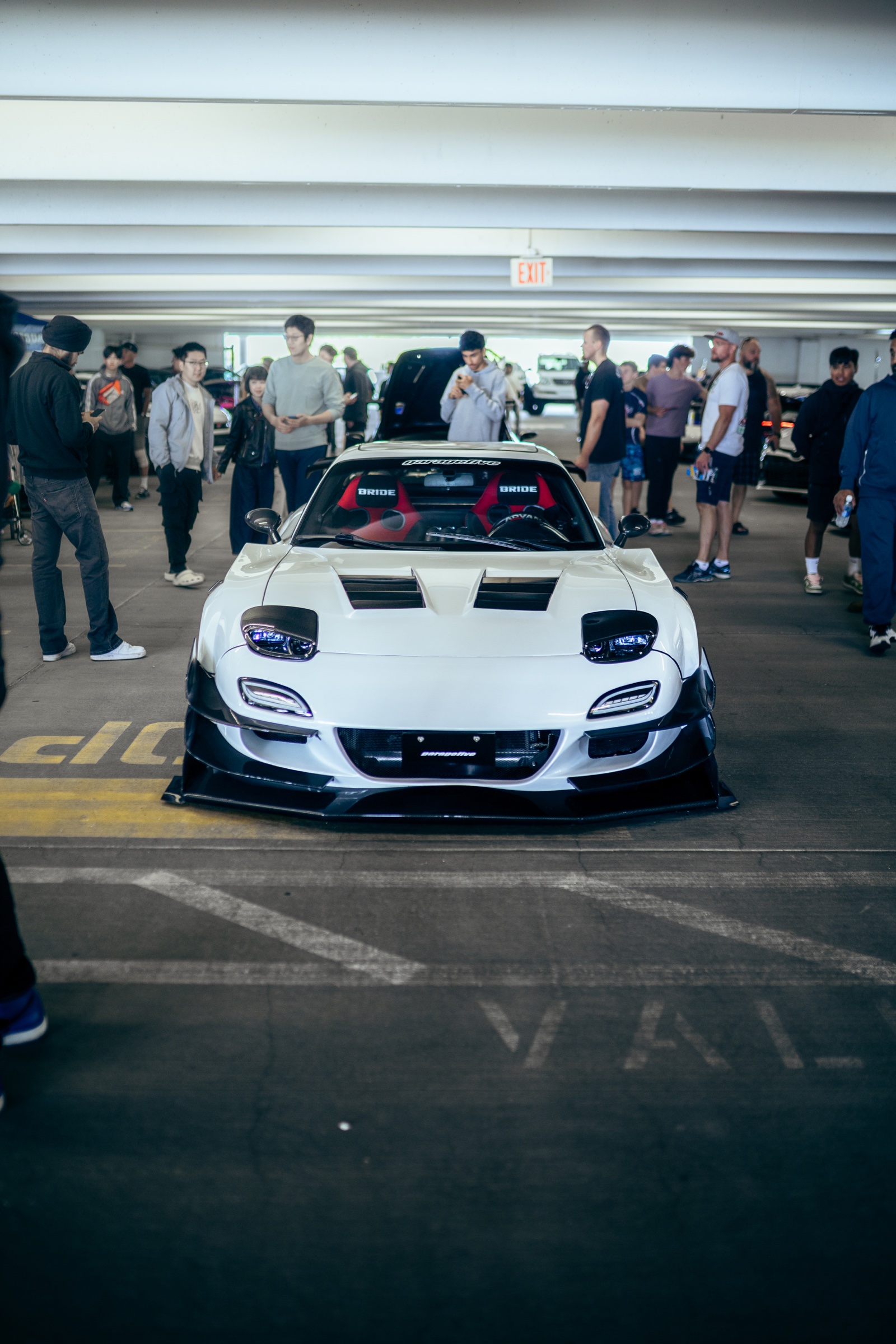 White widebody Mazda RX-7 surrounded by the show crowd