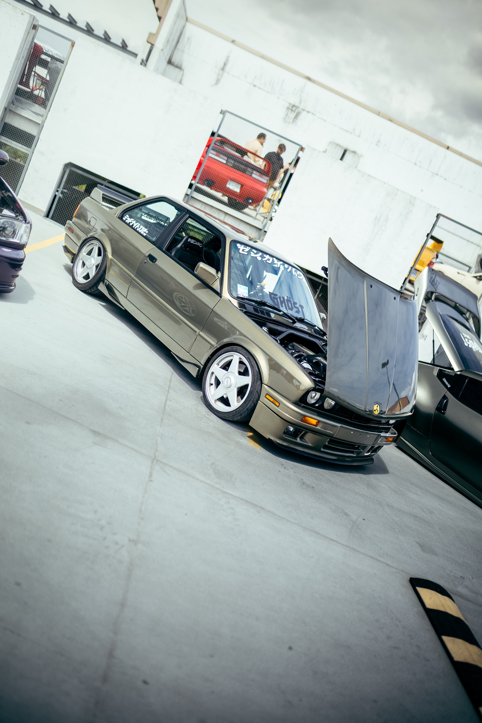 Modified BMW coupe with its hood open on the rooftop