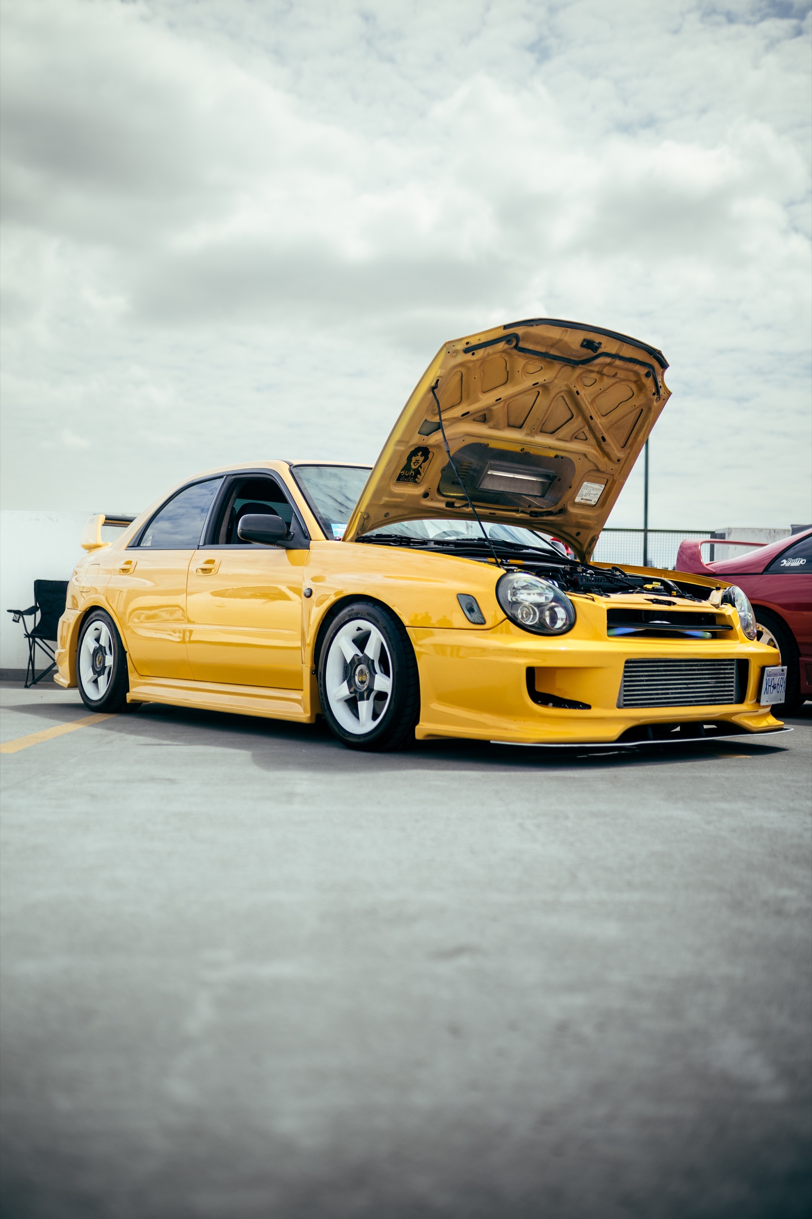 Yellow modified Subaru with its hood open