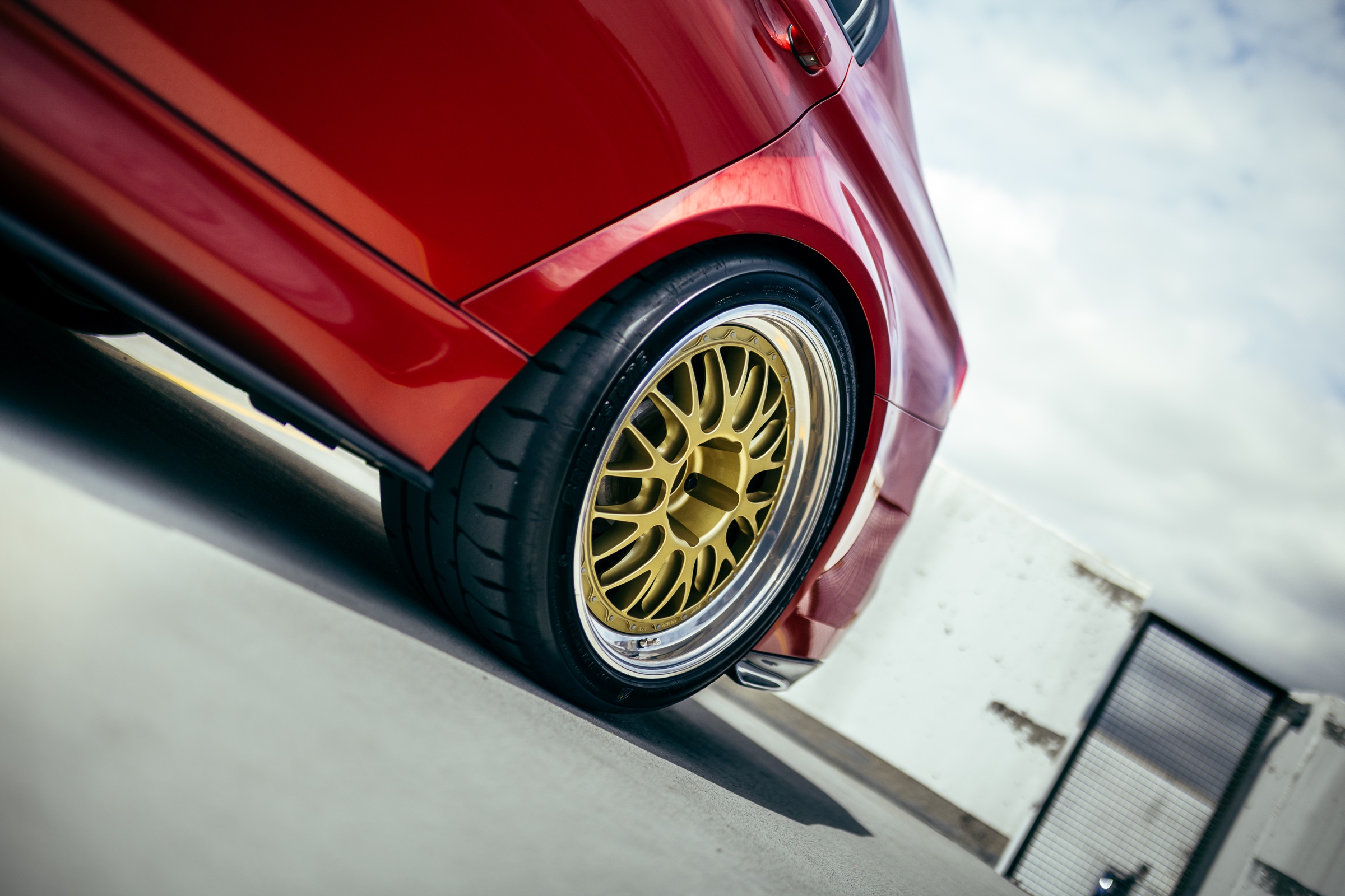 Gold wheel detail on a red BMW M3