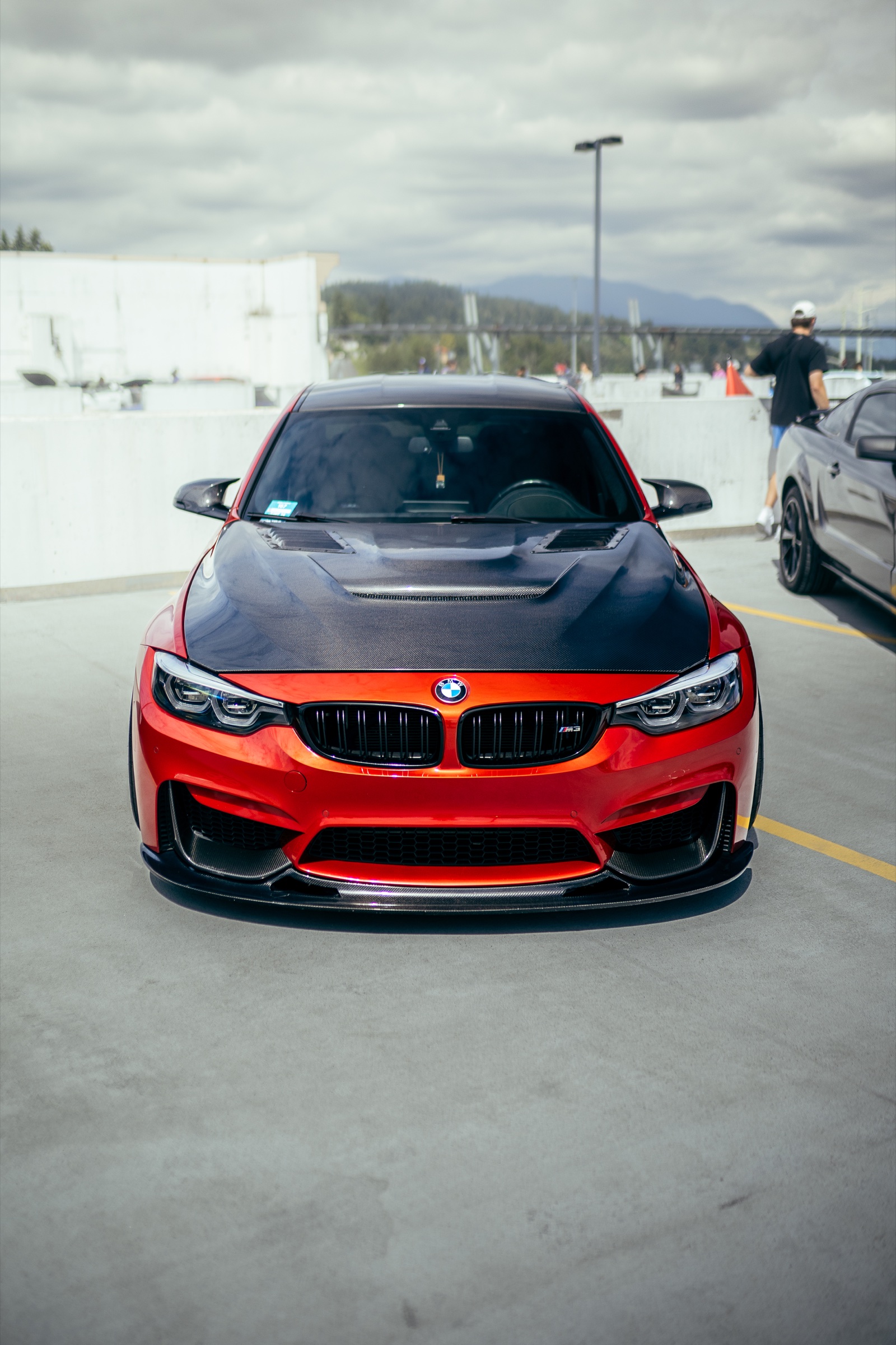 Front view of a red BMW M3 with a carbon-fibre hood