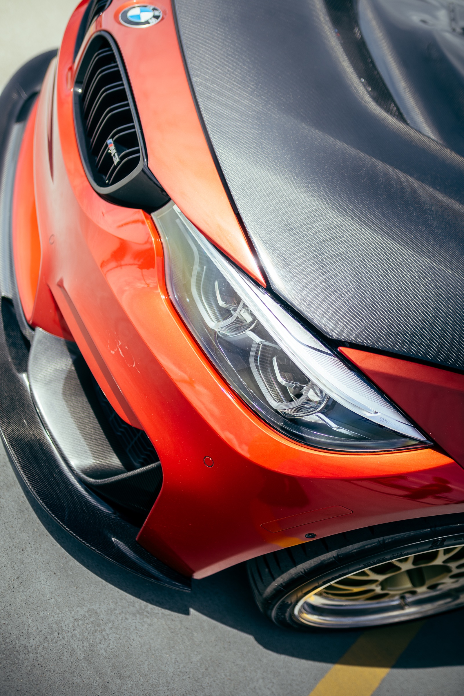 Carbon-fibre and headlight detail on a red BMW