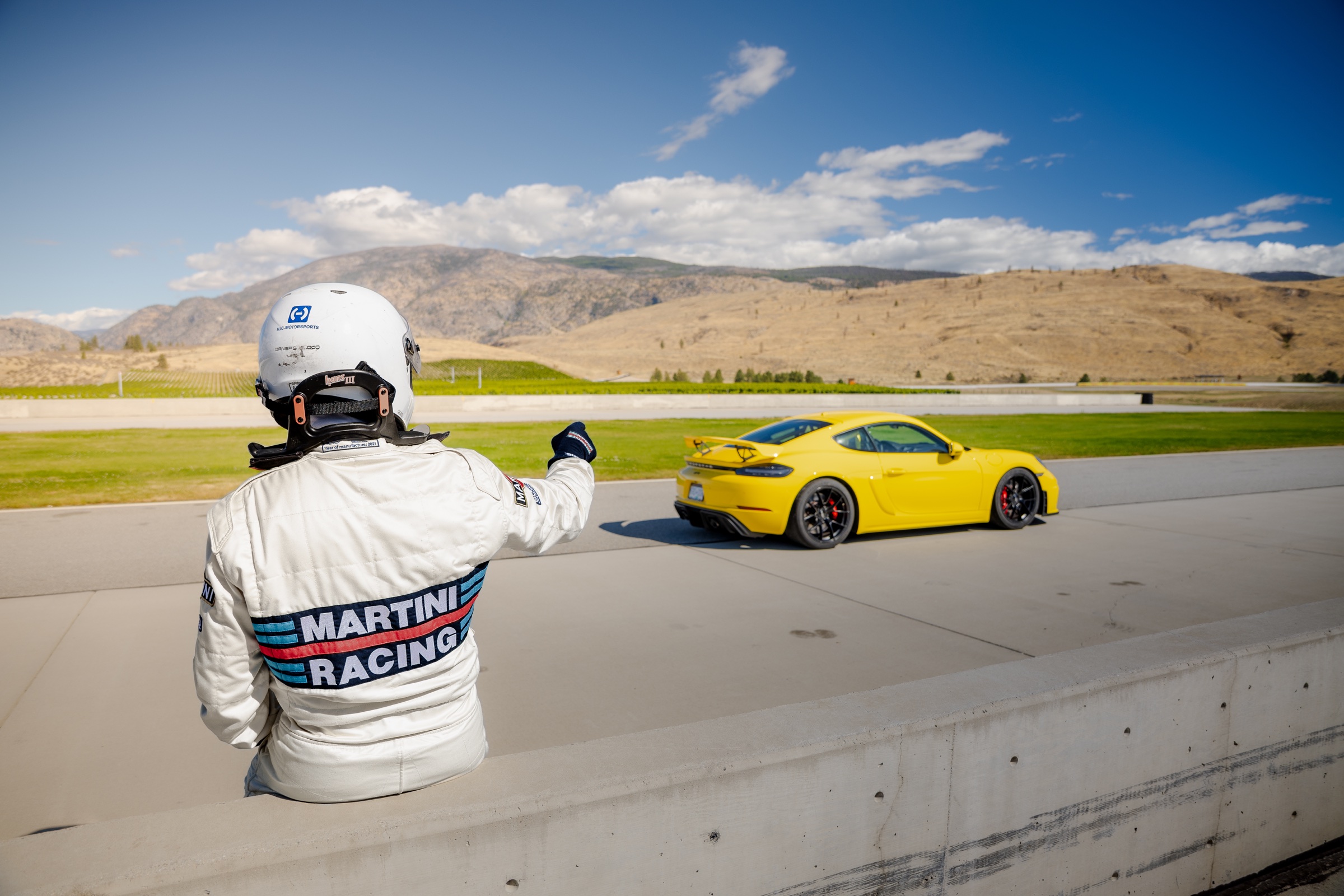 Driver signaling as the Porsche 718 Cayman GT4 enters the circuit
