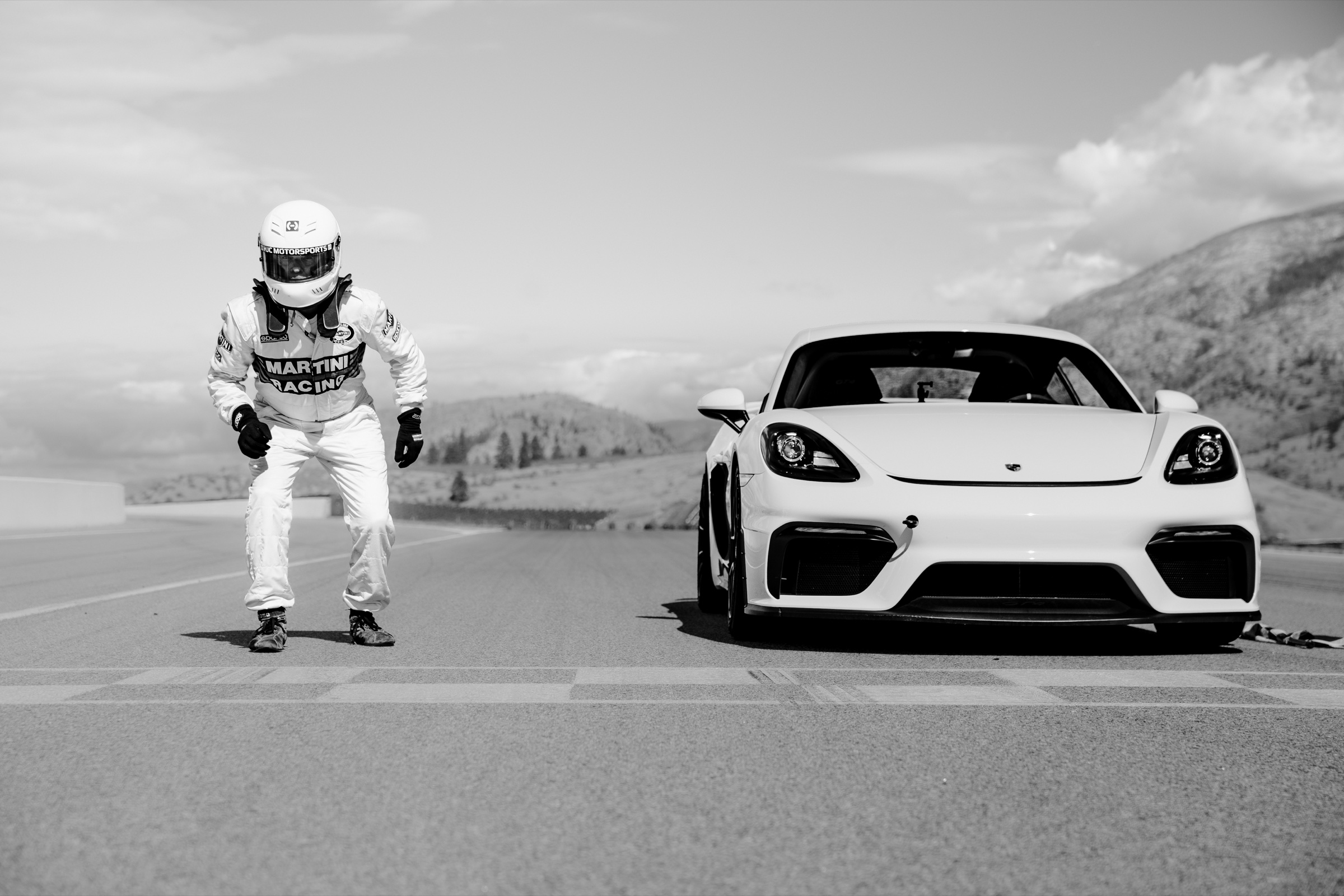 Black-and-white portrait of the driver and Porsche GT4 at the start line