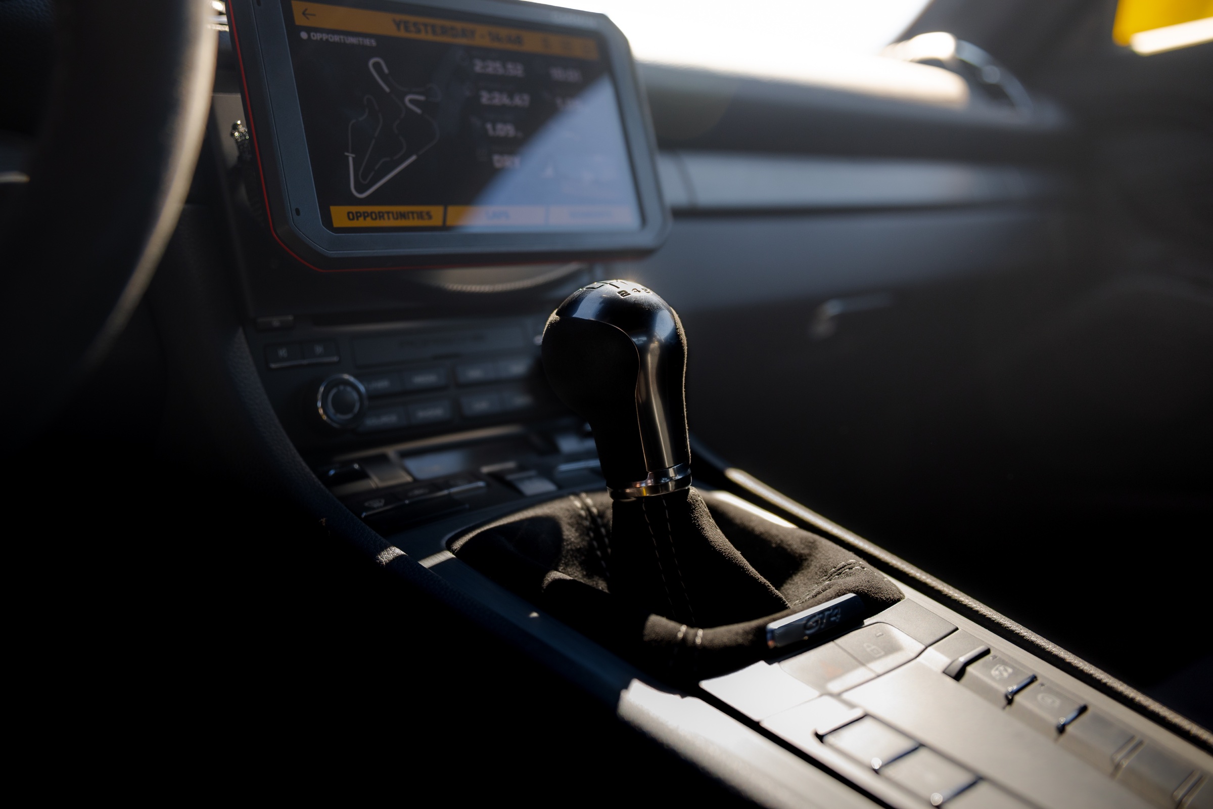 Porsche GT4 manual shifter with Area 27 track display in the cockpit