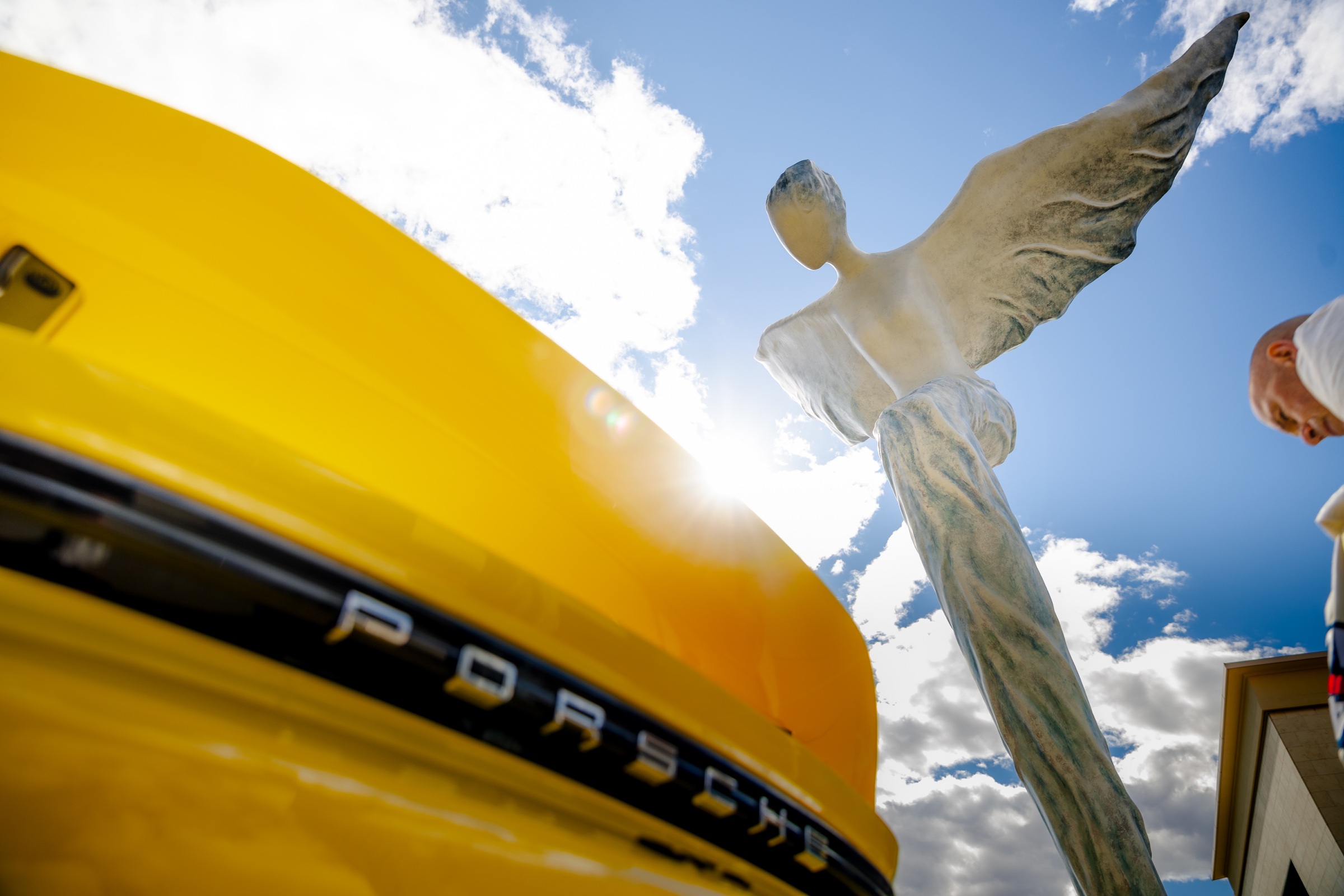 Low-angle Porsche GT4 detail beneath the Area 27 winged sculpture