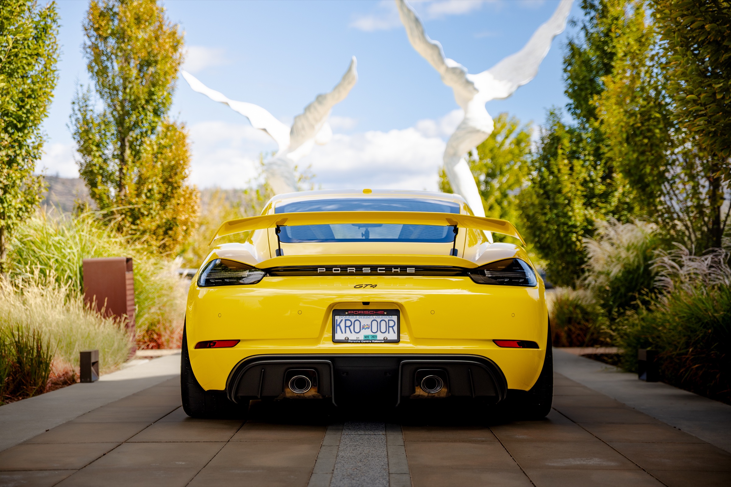 Rear view of a yellow Porsche 718 Cayman GT4 at Area 27