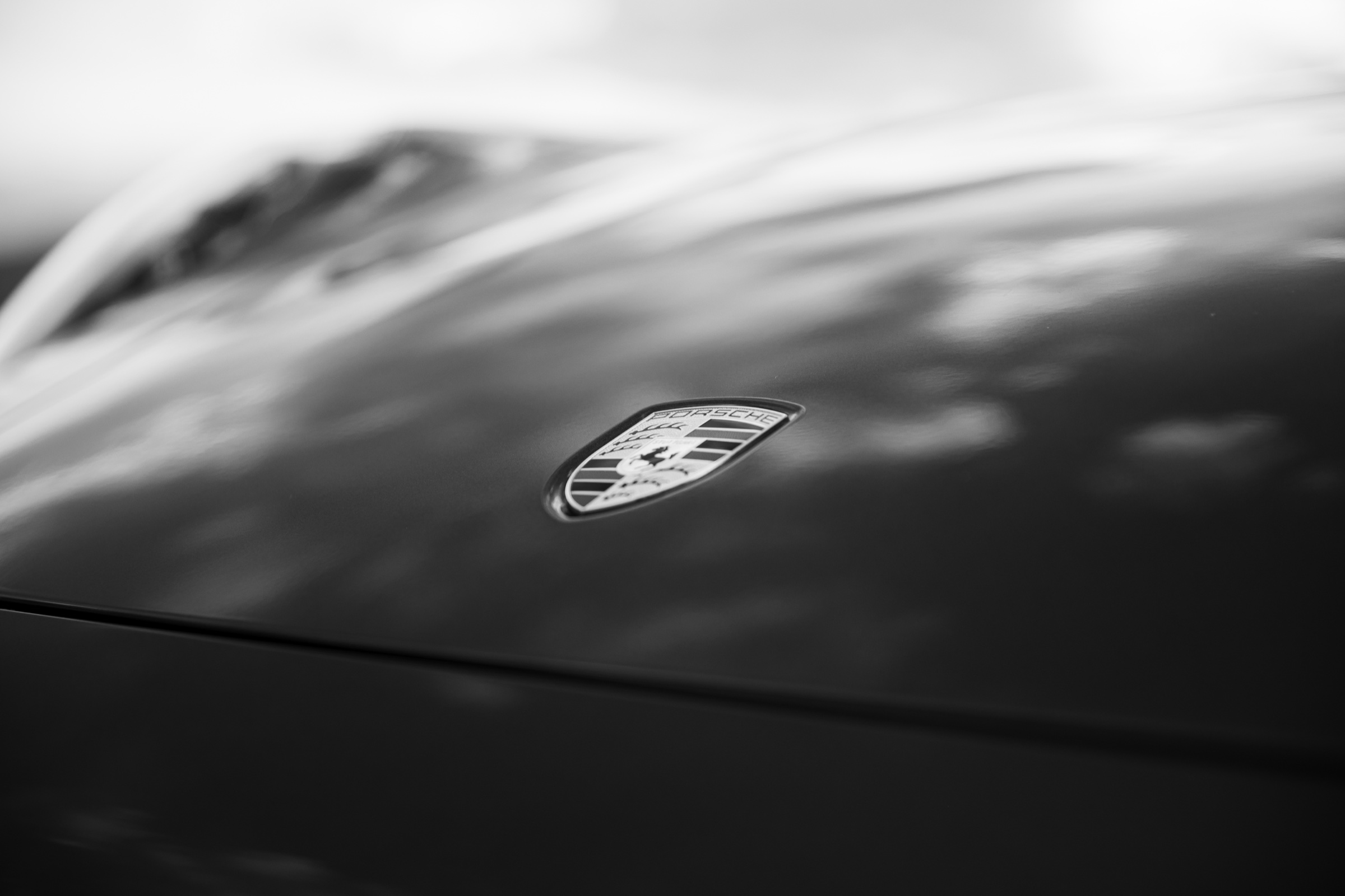 Black-and-white detail of the Porsche crest on the hood
