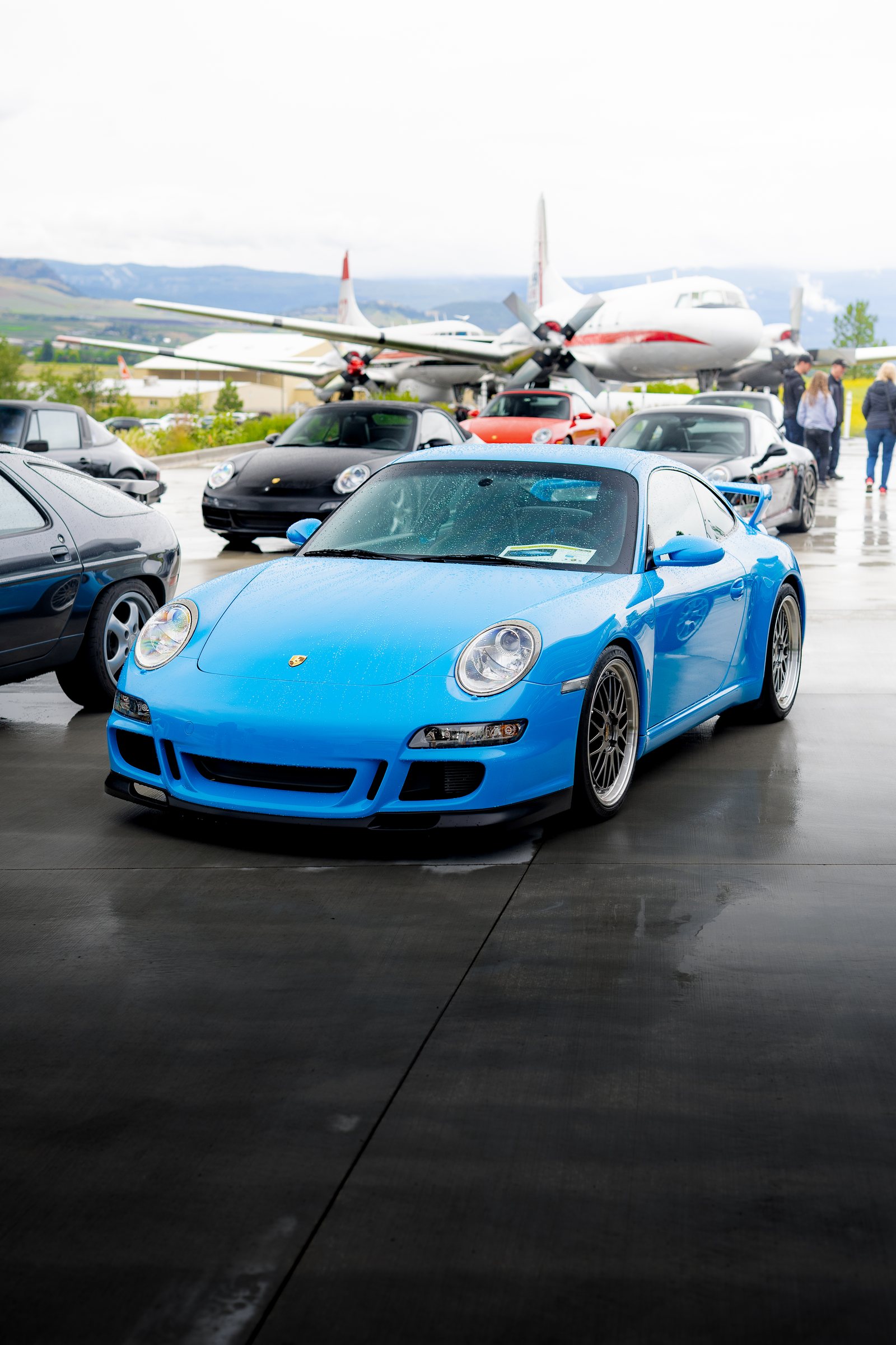 Porsche framed beneath an aircraft display at the event