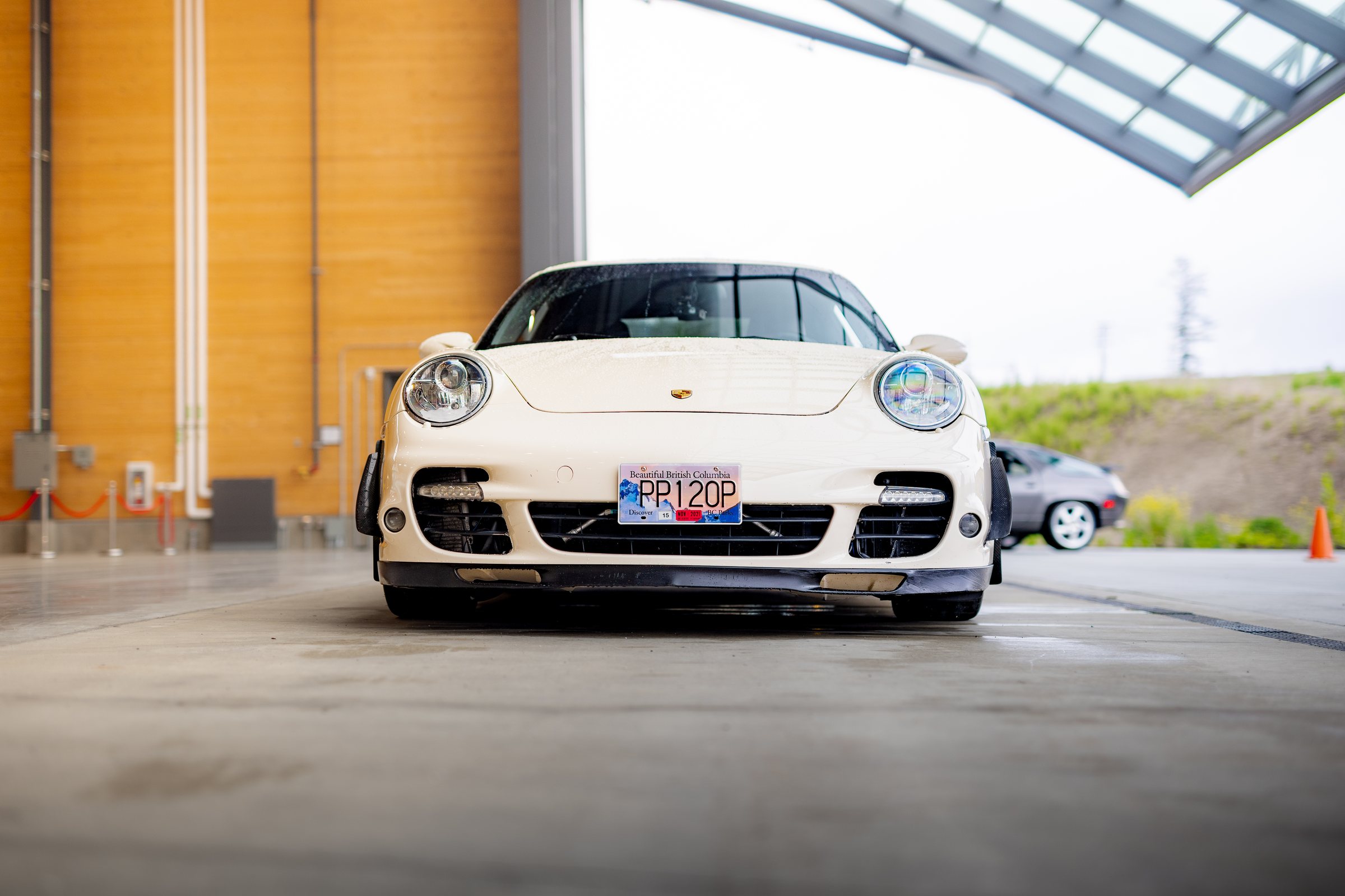 White Porsche 911 Turbo photographed head-on in the hangar
