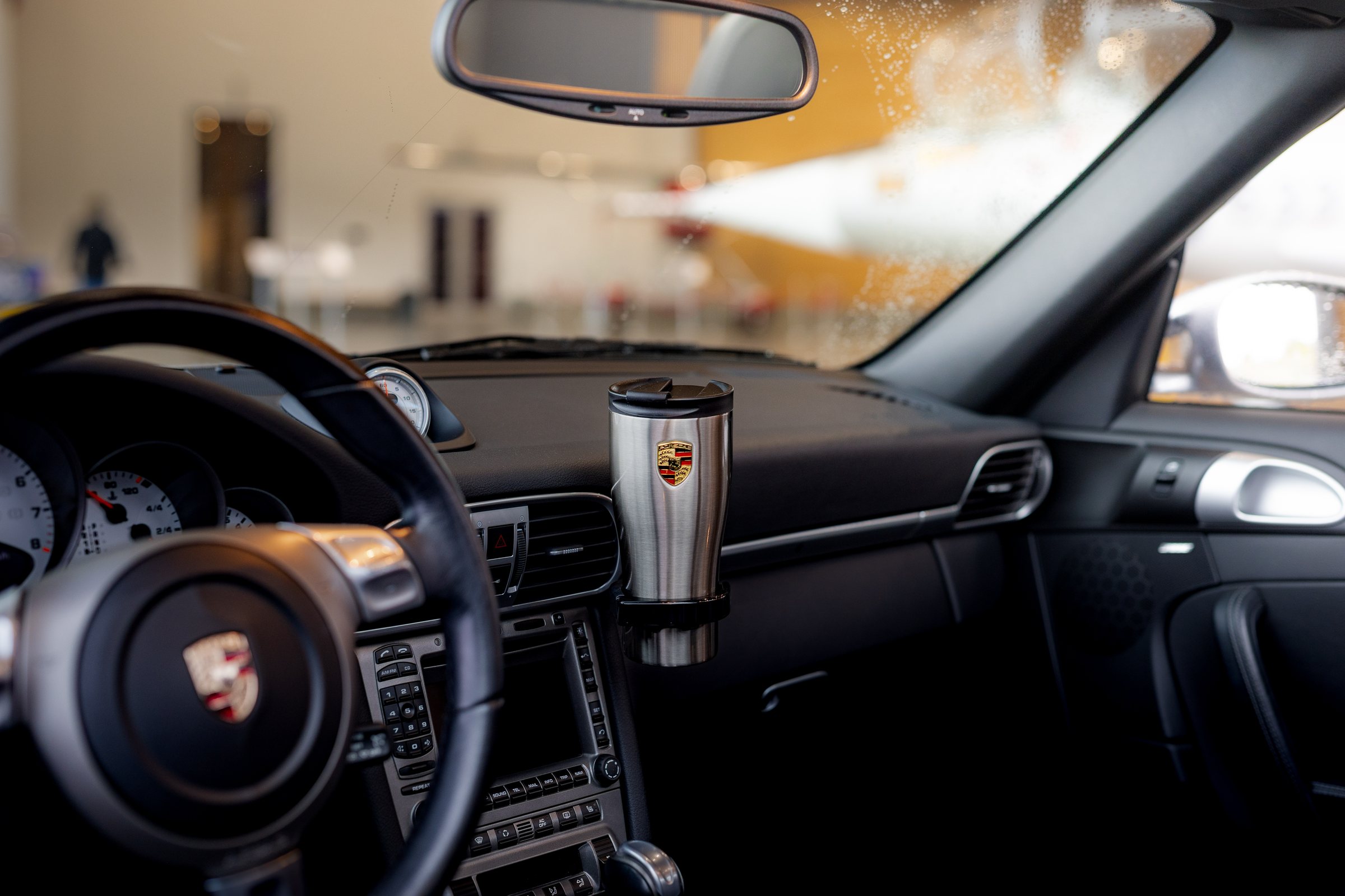 Porsche interior with a crested travel tumbler