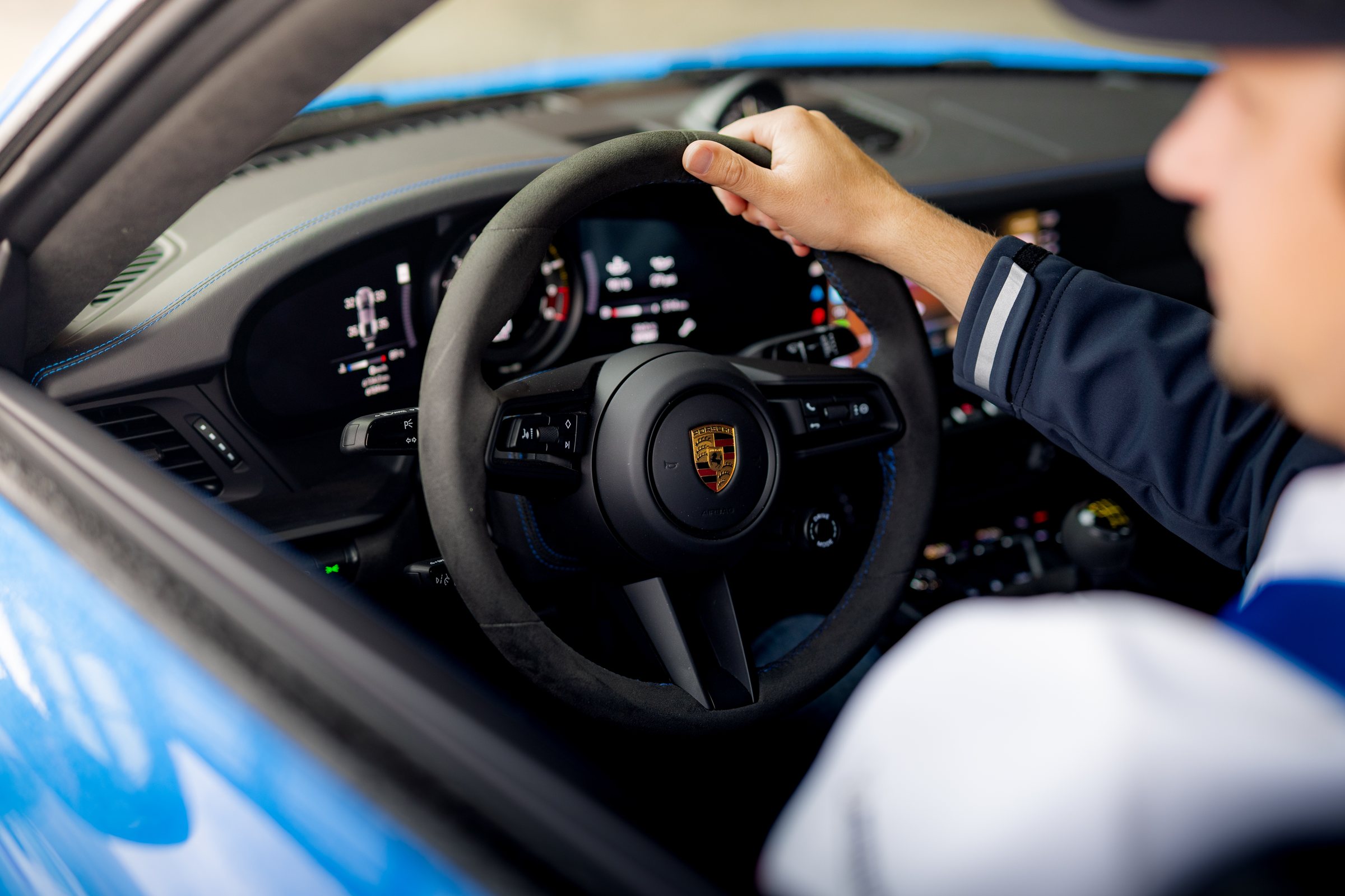 Driver seated inside a blue Porsche 911 GT3
