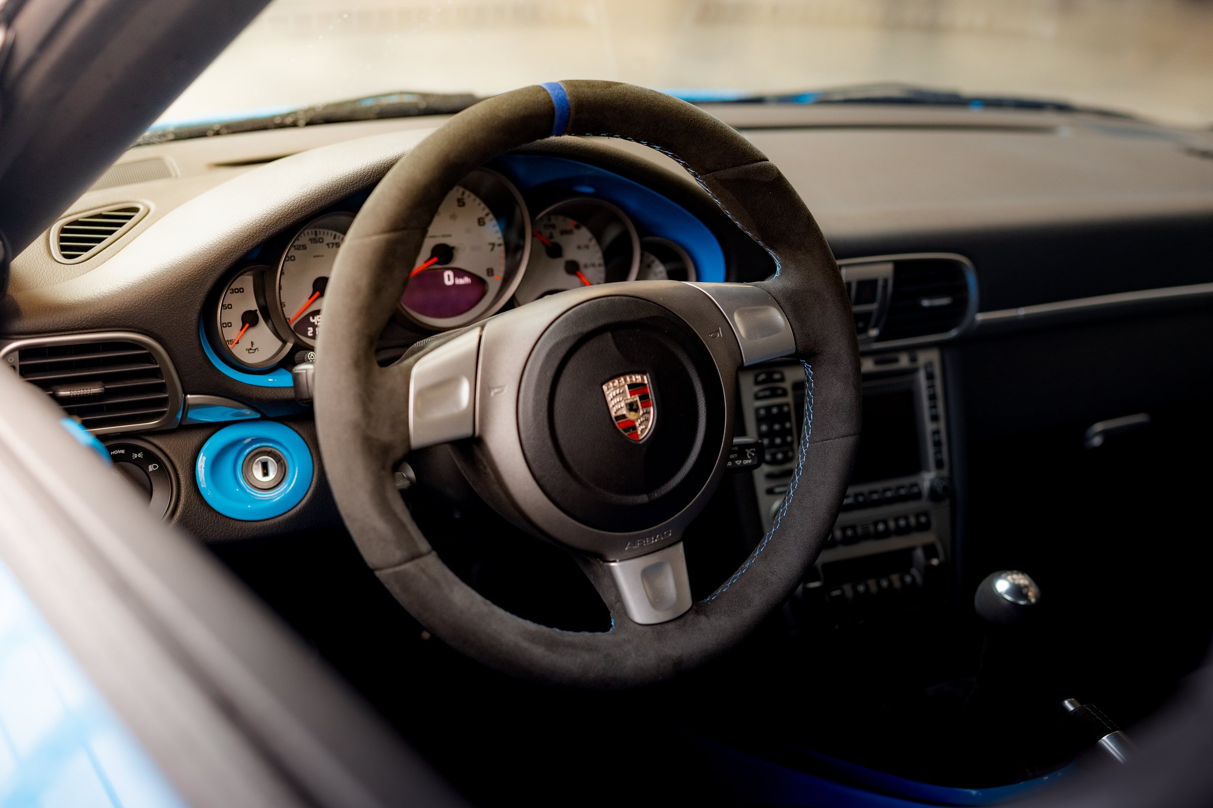 Alcantara steering wheel inside a blue Porsche