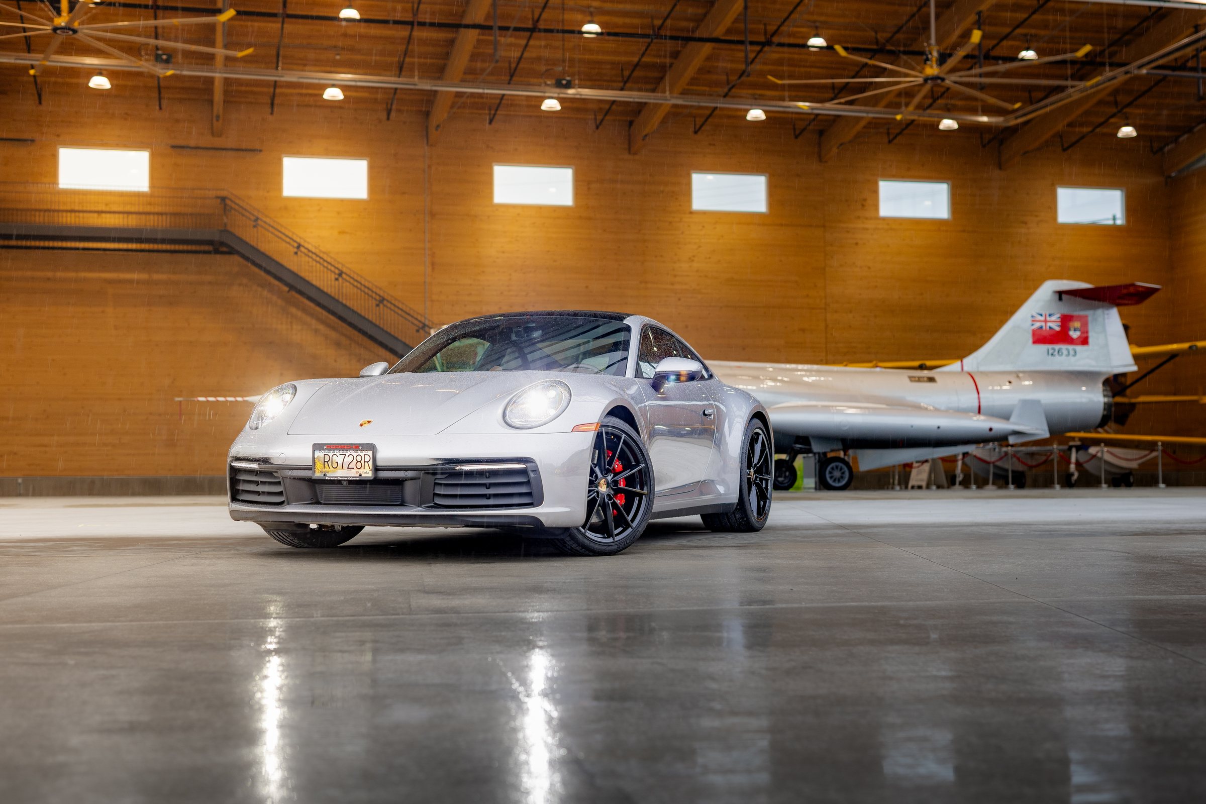 Silver Porsche 911 photographed with an RCAF aircraft