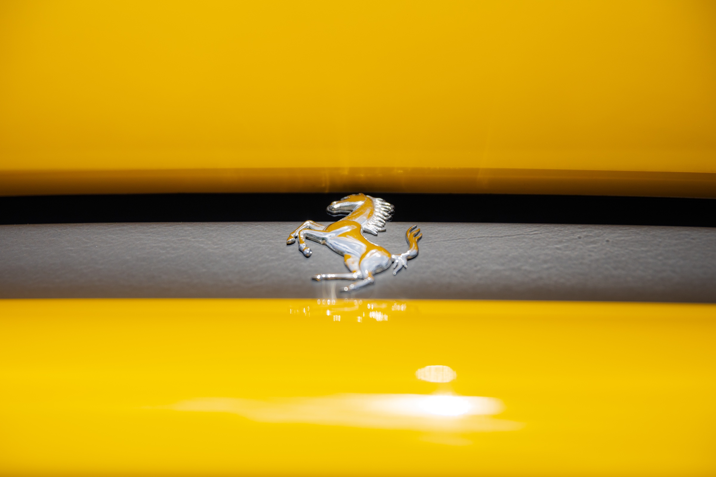 Ferrari prancing-horse badge framed by yellow bodywork