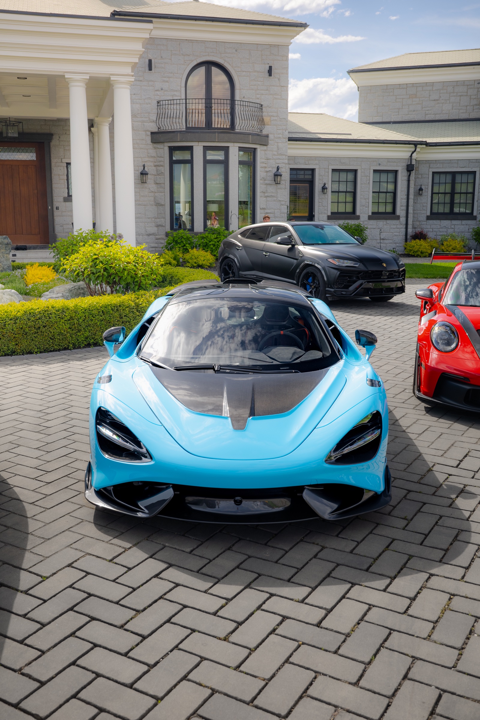 Front portrait of a blue McLaren 765LT among the collection