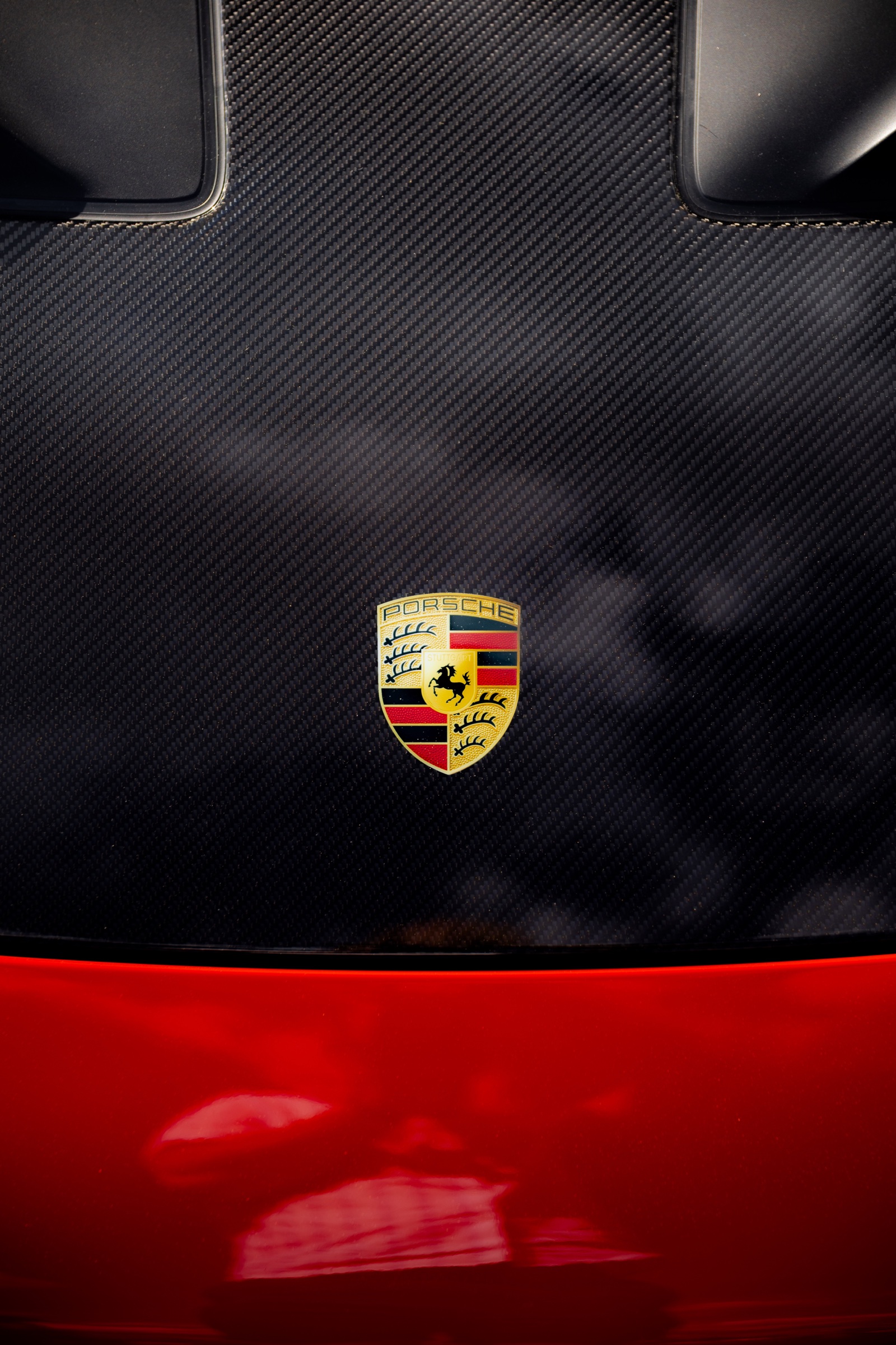 Porsche crest set into exposed carbon-fibre bodywork